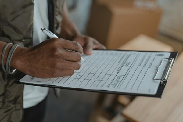a person filling up a form on a clipboard