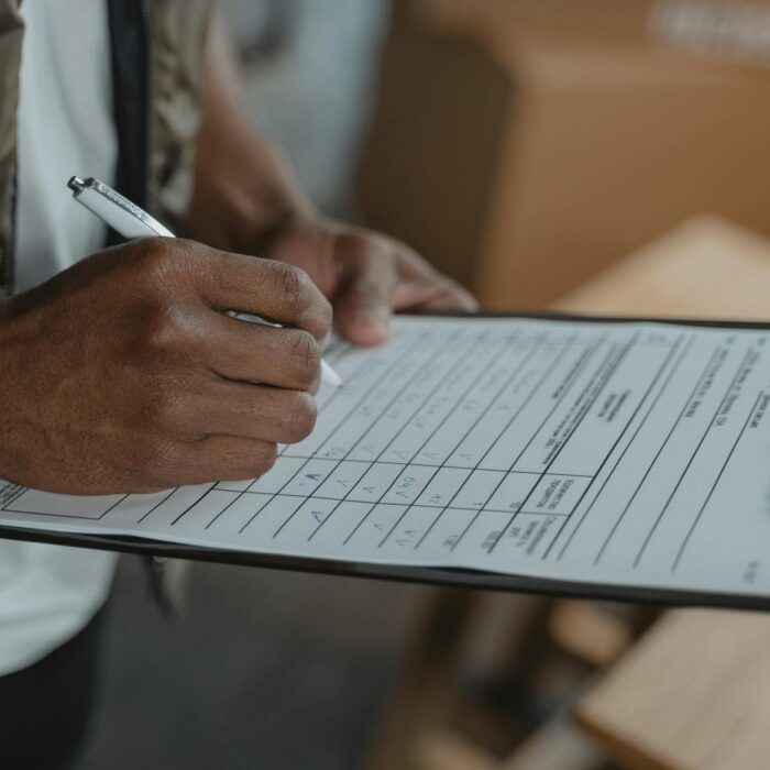 a person filling up a form on a clipboard